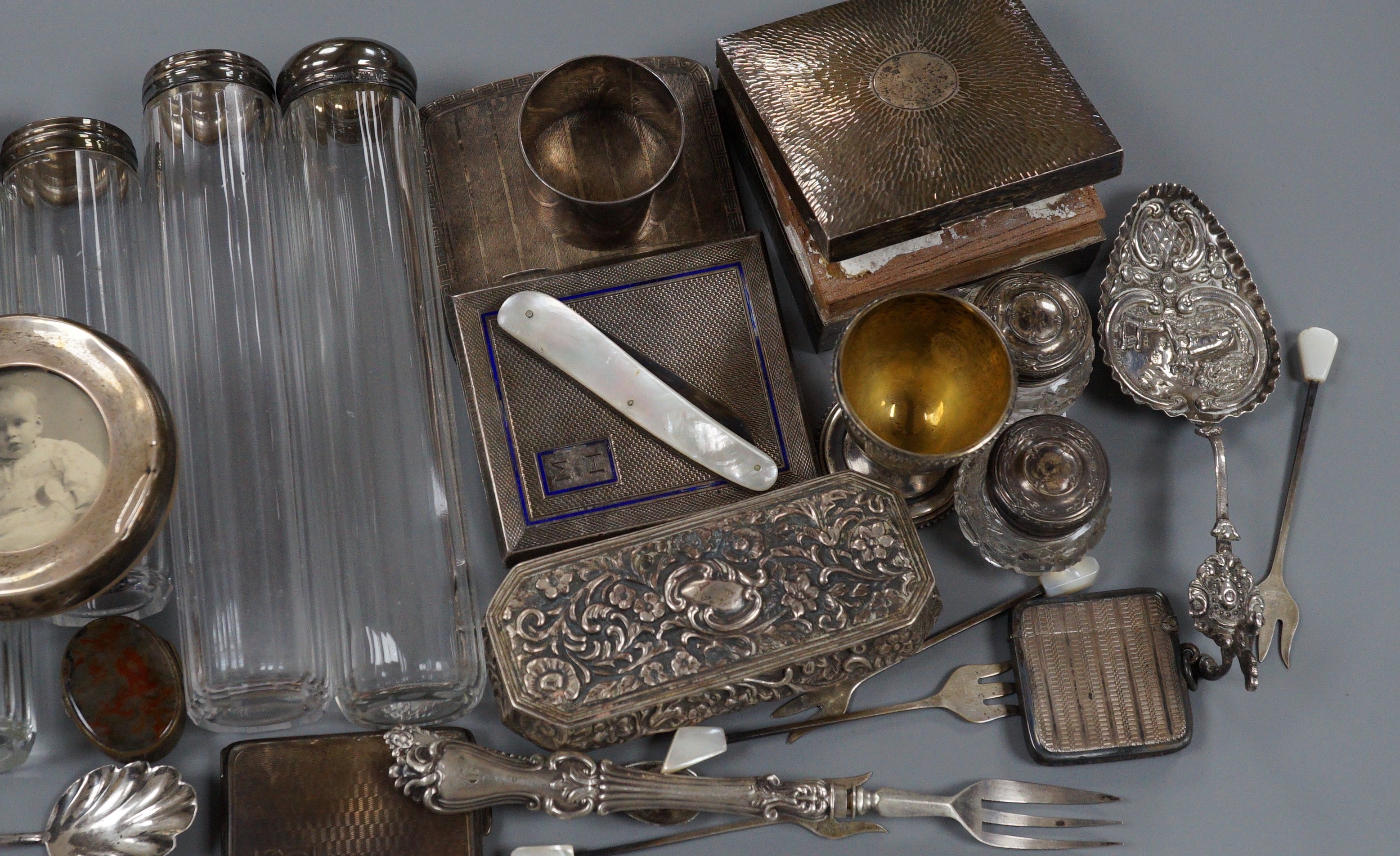 A collection of assorted collectable silver items, including a George V spectacles case, cigarette box, trinket box, Dutch spoon, mounted glass power jar, egg cup, enamelled cigarette case, vesta case, fruit knife, napki
